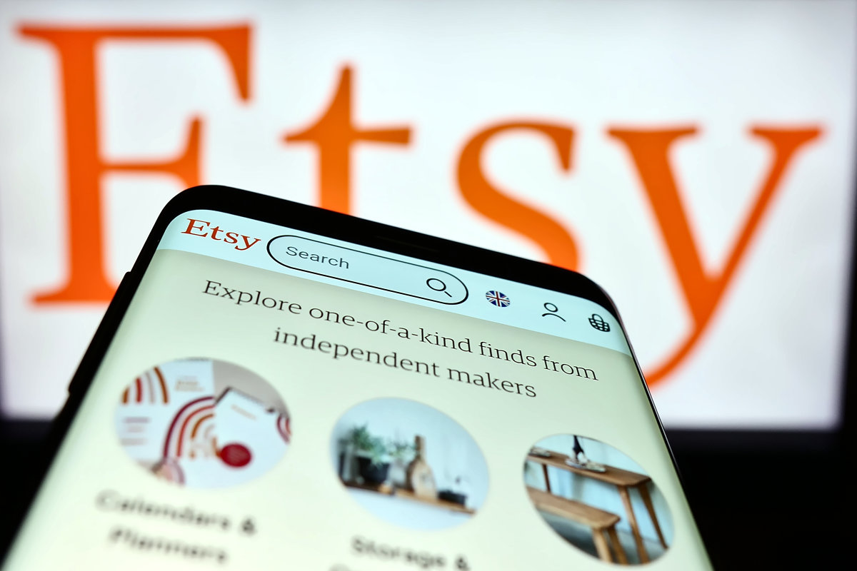 Etsy App on Smartphone with Logo in Background